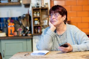 a woman sitting at a table with a cell phone